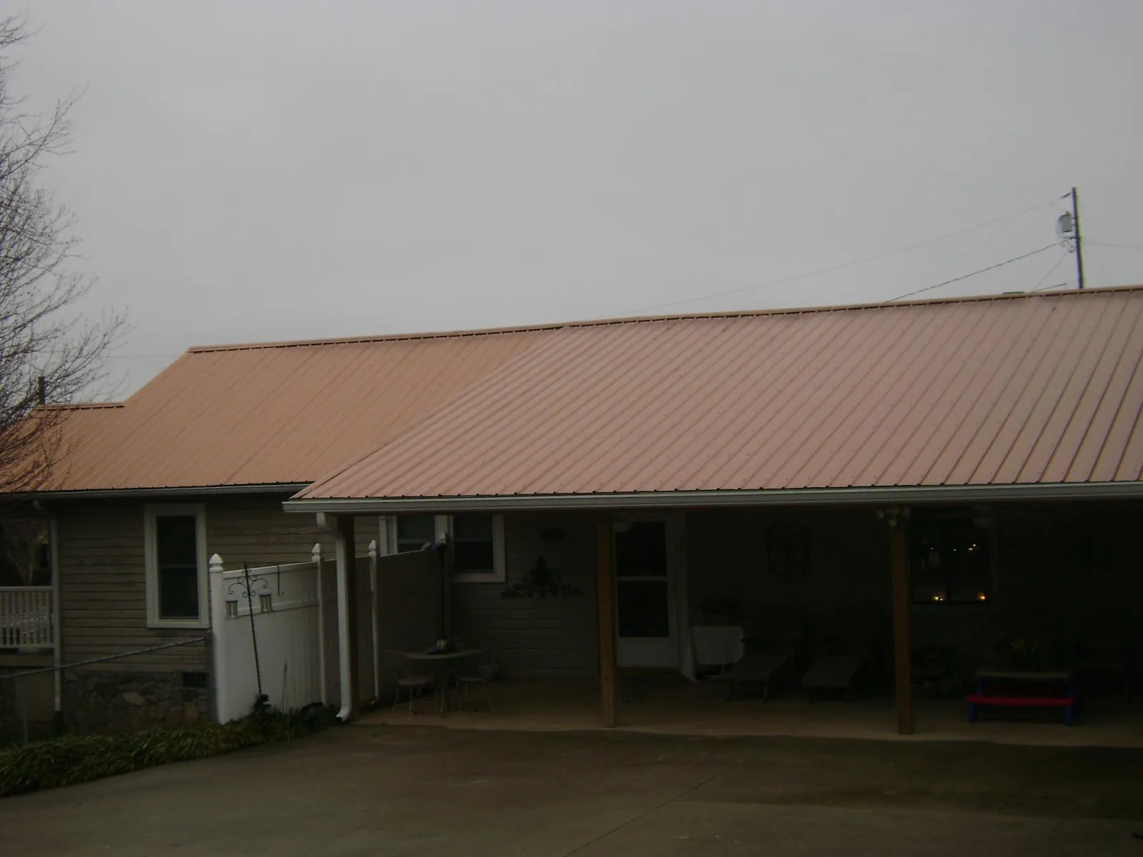 Copper toned metal roof over a wide covered patio in Wendell